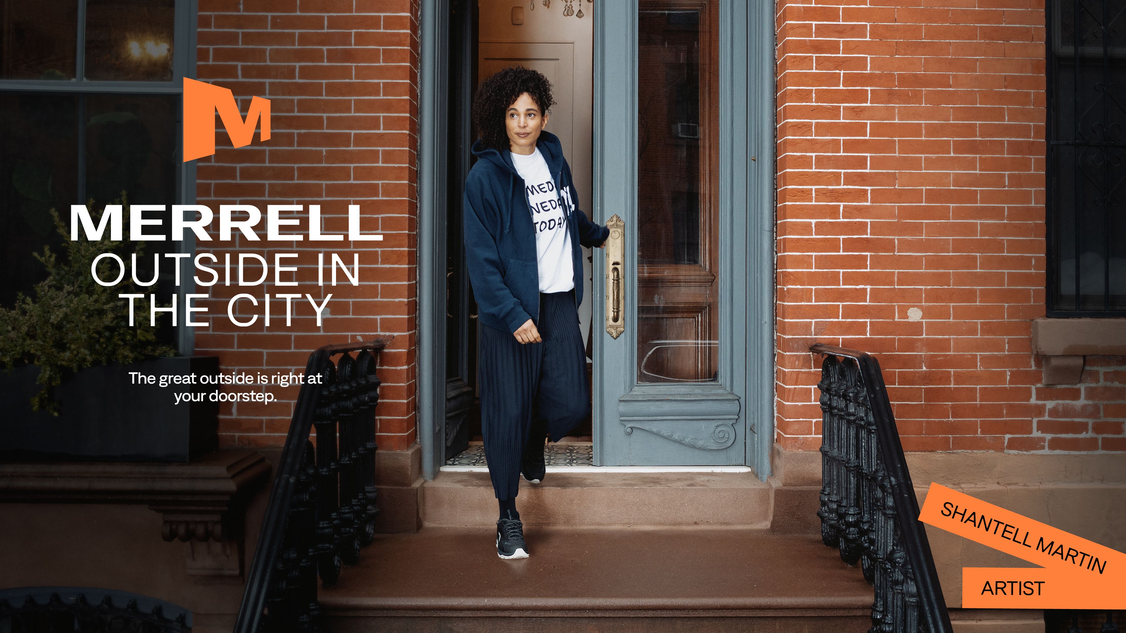 Shantell Martin emerging from a brick building.